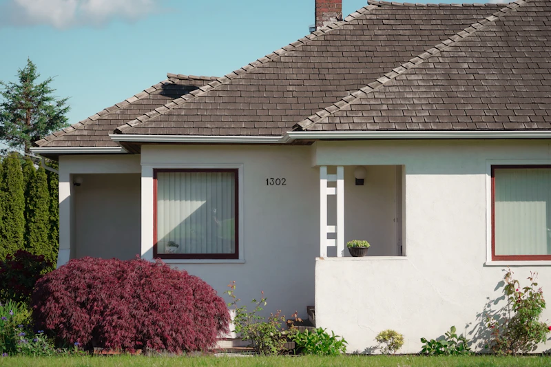 White house with red trim and a brown roof