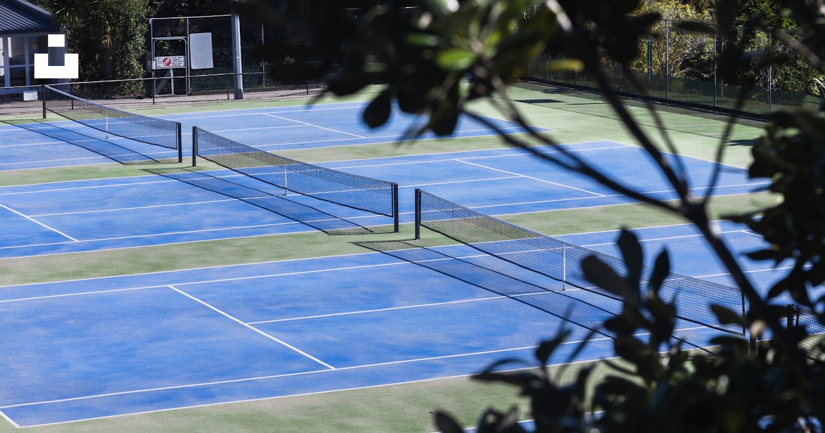 A tennis court with several tennis courts surrounded by trees photo A tennis court with several tennis courts surrounded by trees photo