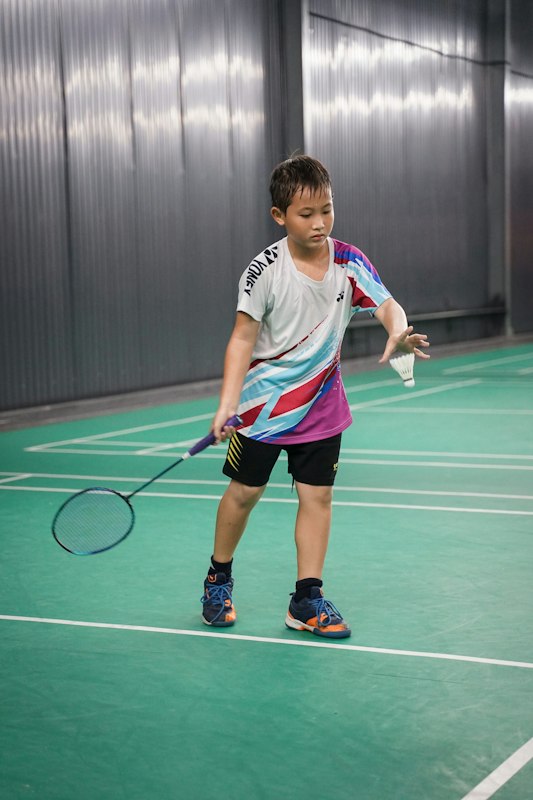 サーブの構えをする少年