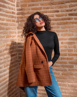 a woman standing in front of a brick wall