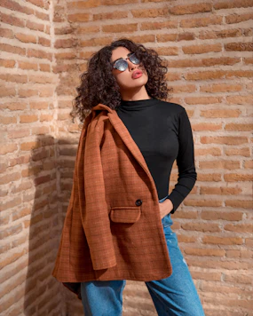 a woman standing in front of a brick wall