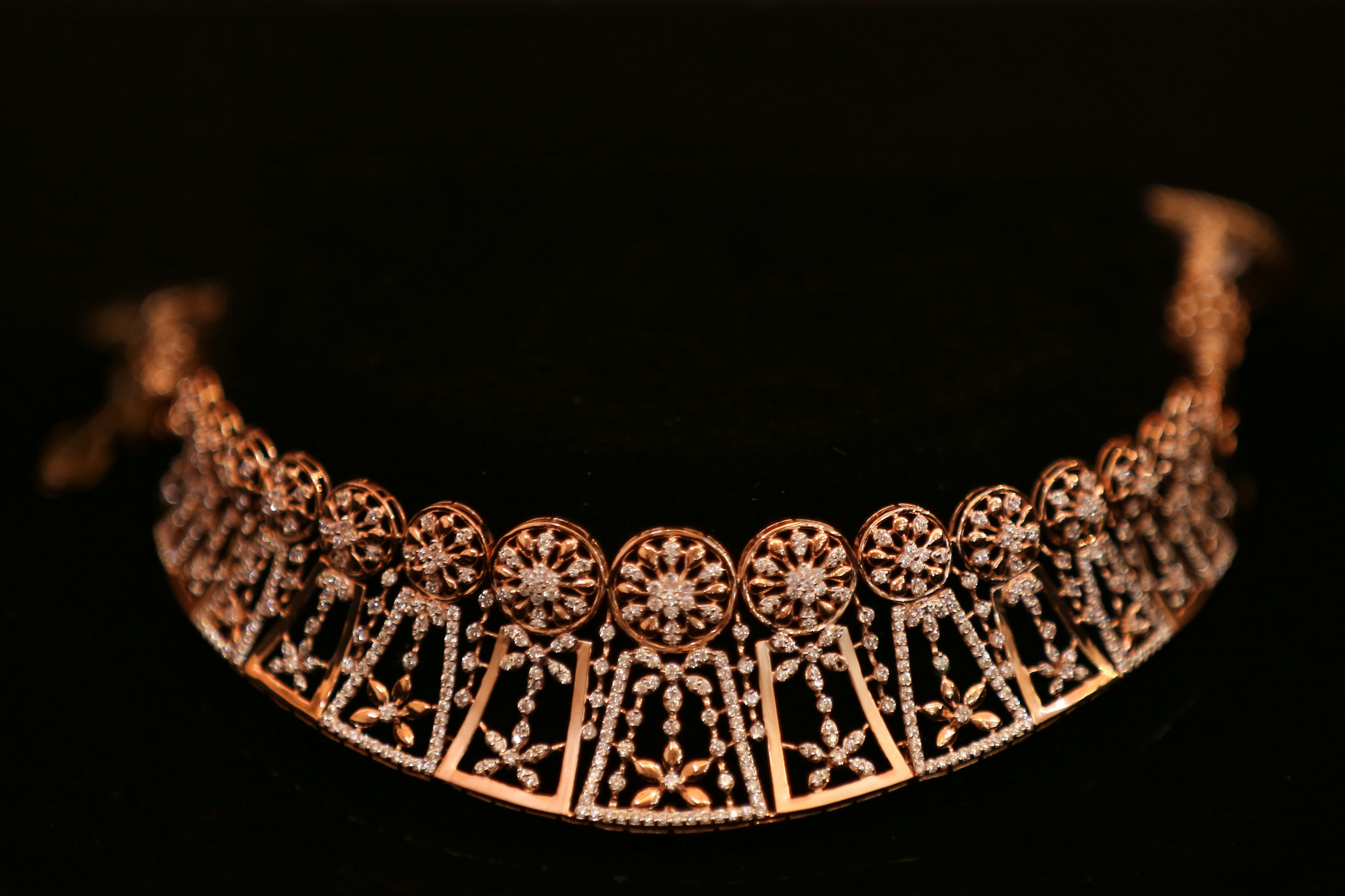 Intricate gold arabesque necklace on dark background