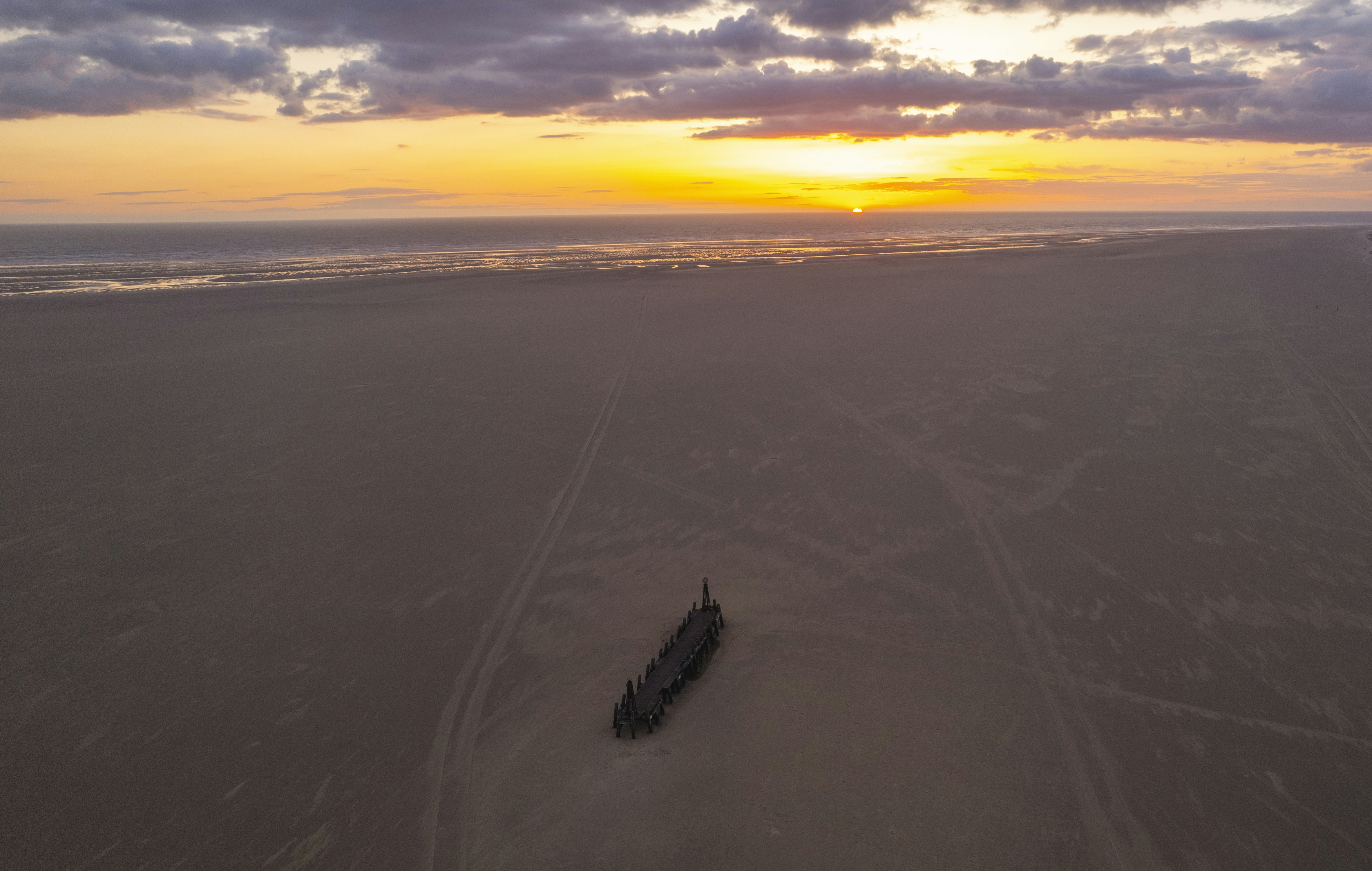 Ein Zug, der unter bewölktem Himmel durch eine Wüste fährt