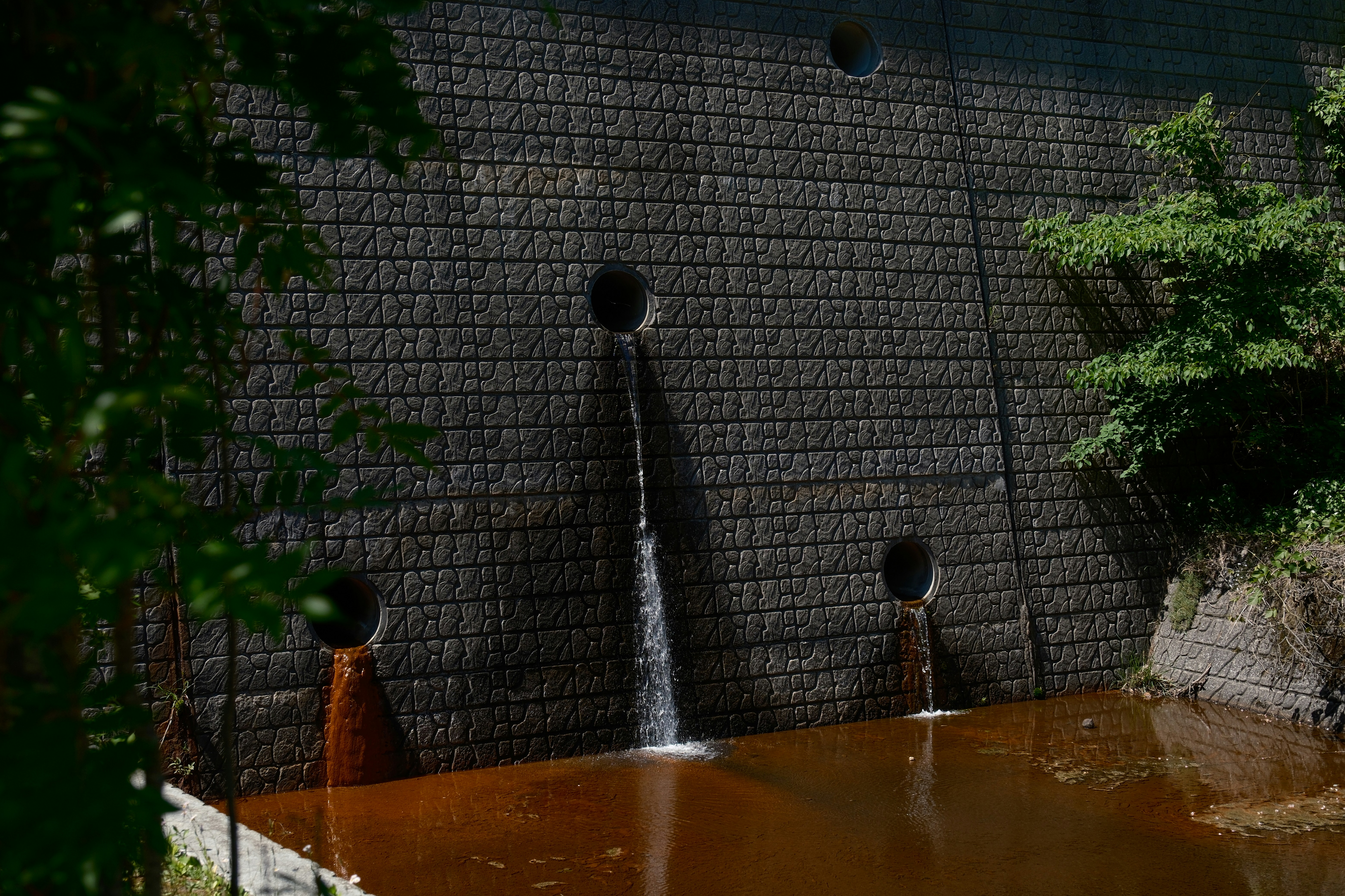 a brick wall with water coming out of it