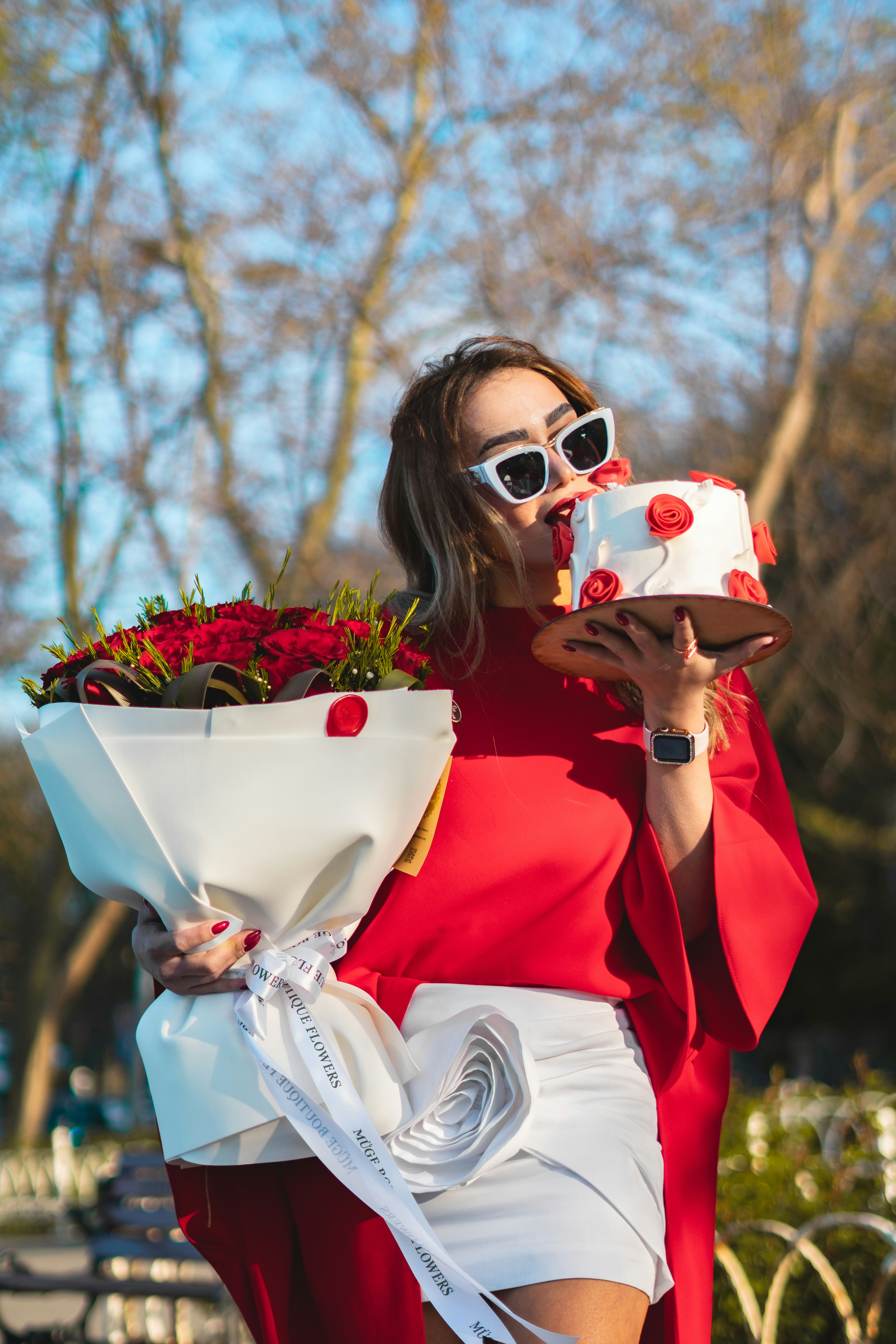 a woman in a red dress holding a cake