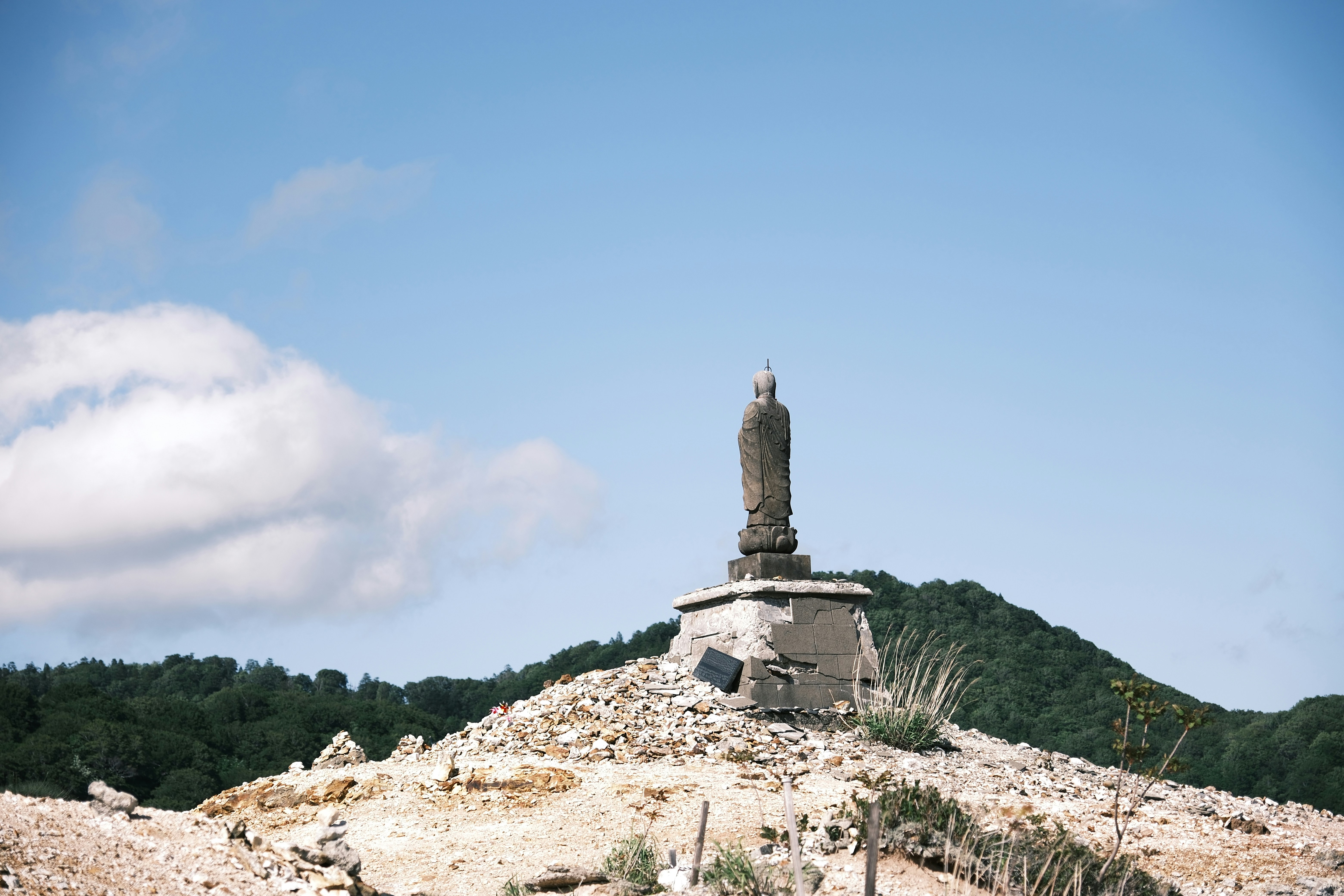 a statue on top of a hill with a sky background