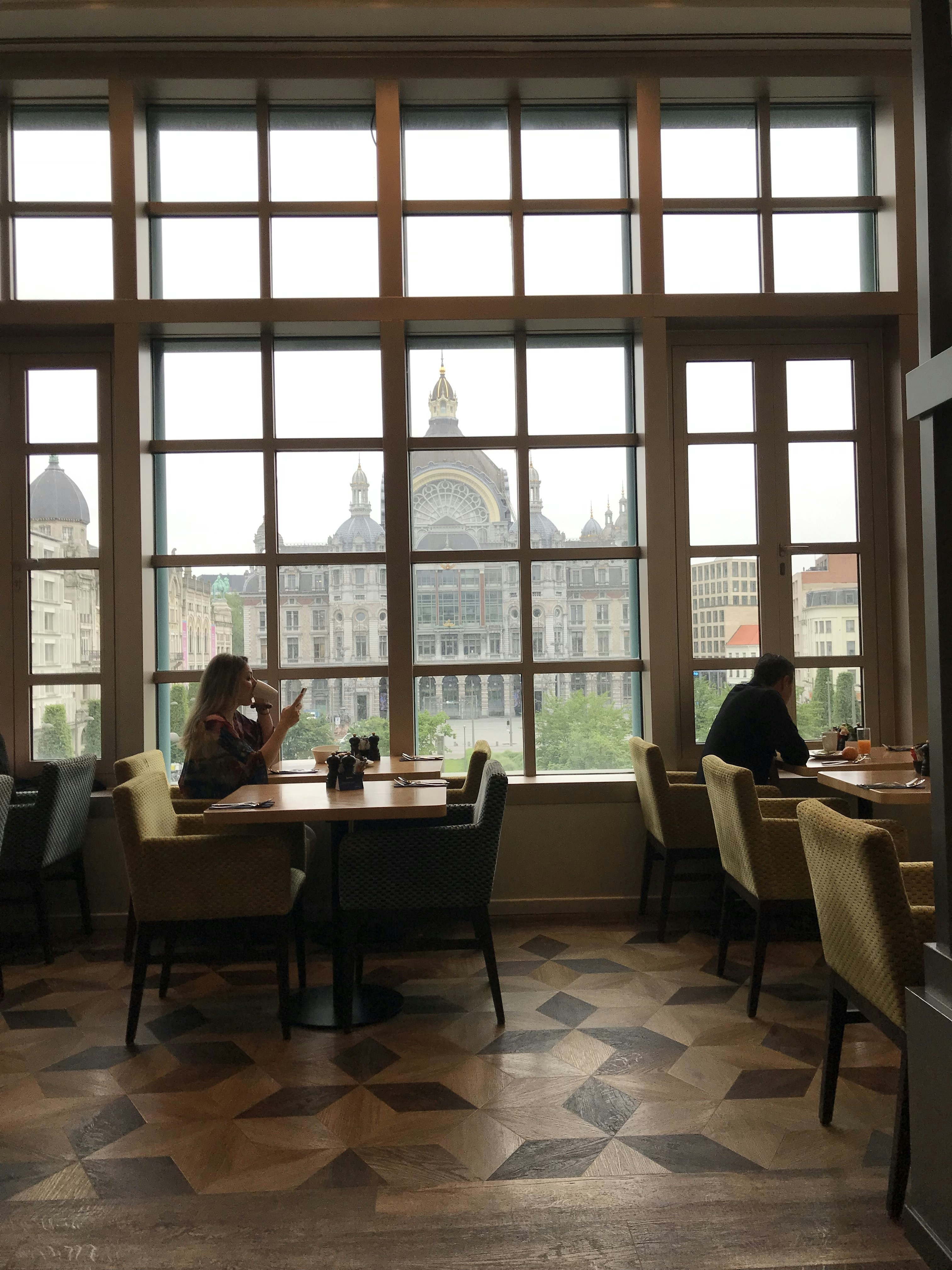 ein paar Leute, die an einem Tisch vor einem Fenster sitzen