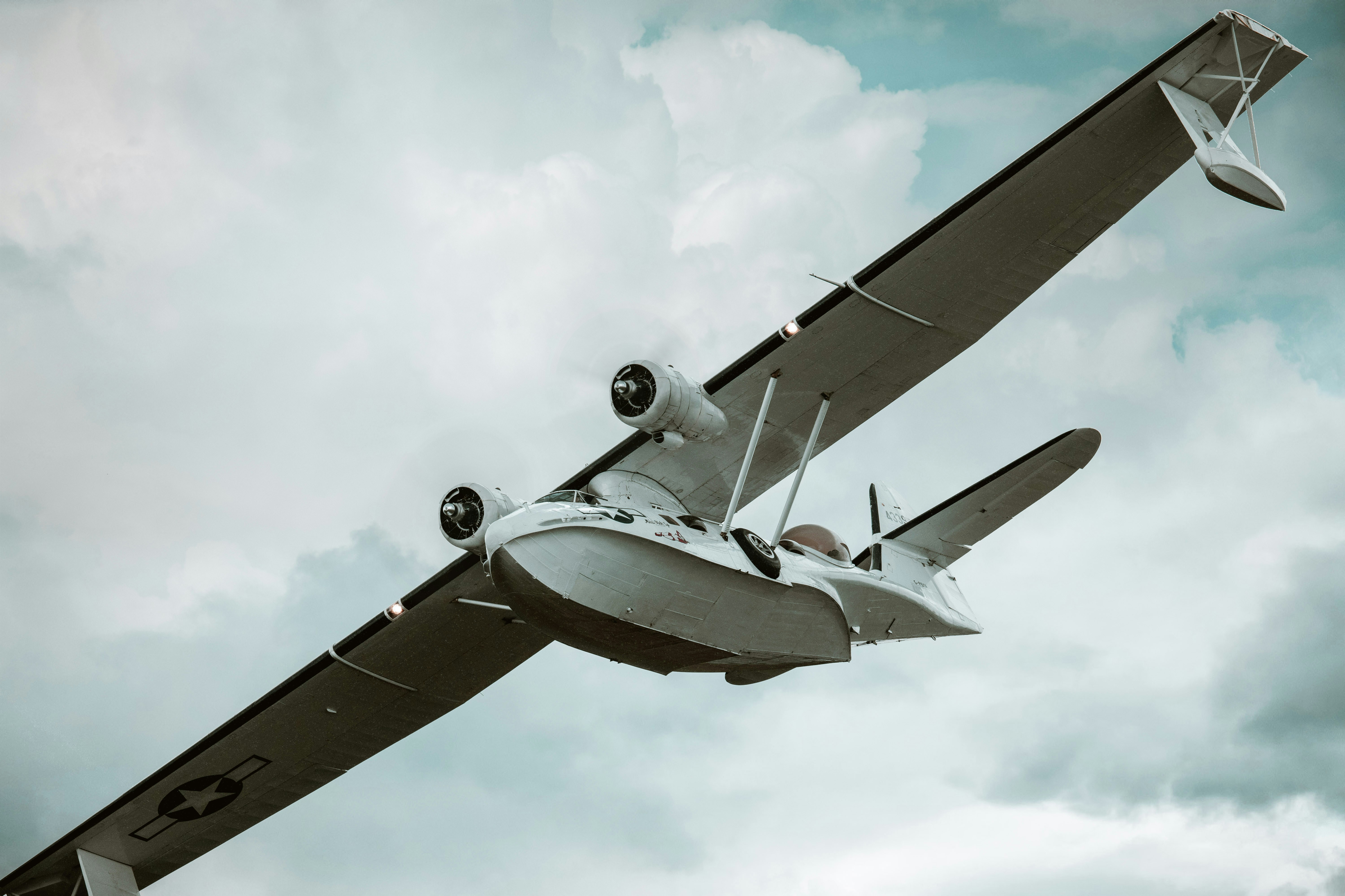 a small airplane flying through a cloudy sky, 