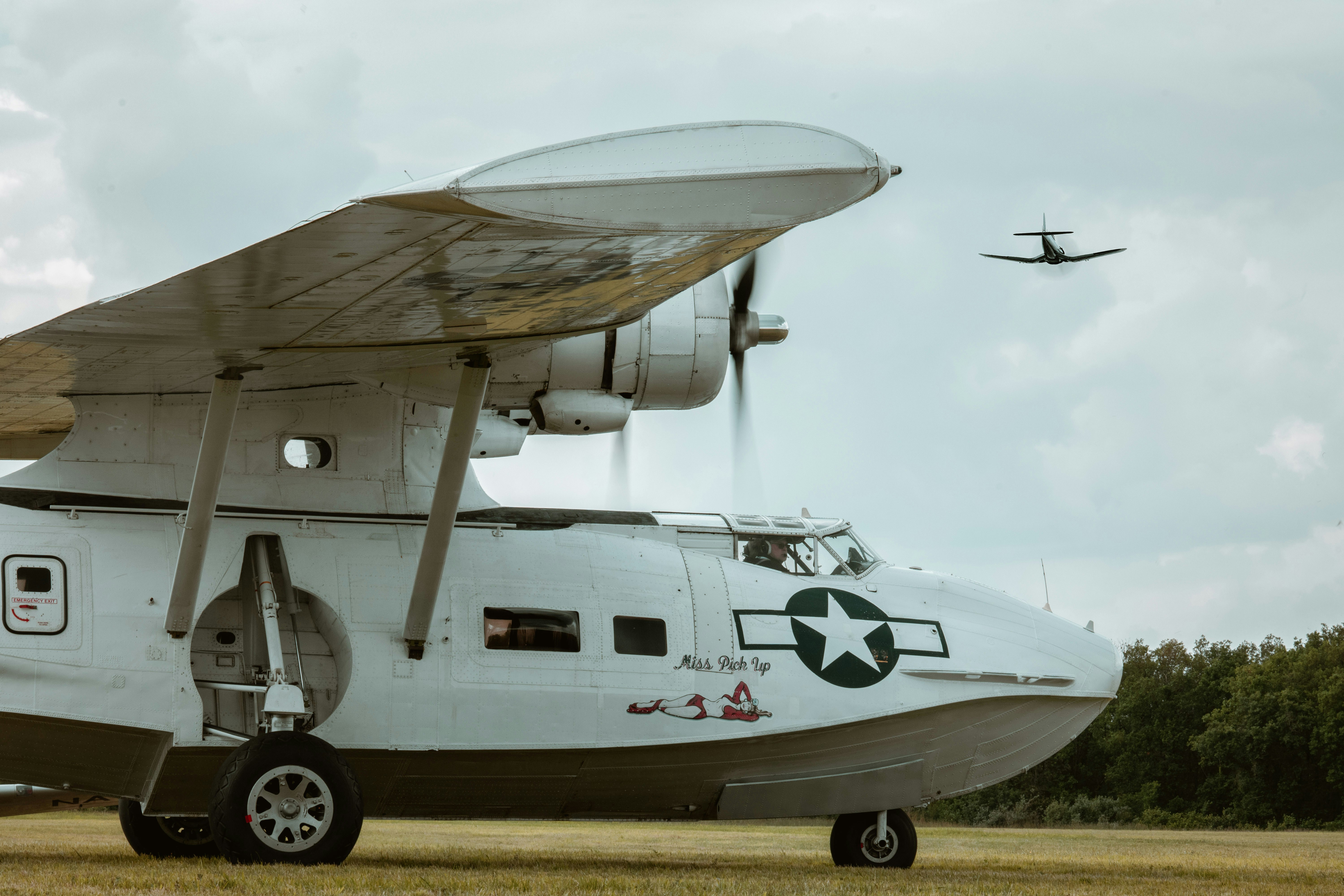 an airplane with a propeller sitting in a field, 