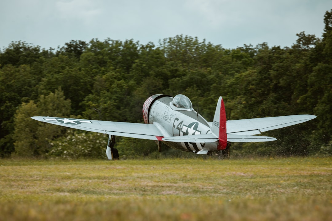 a small airplane sitting on top of a grass covered field,