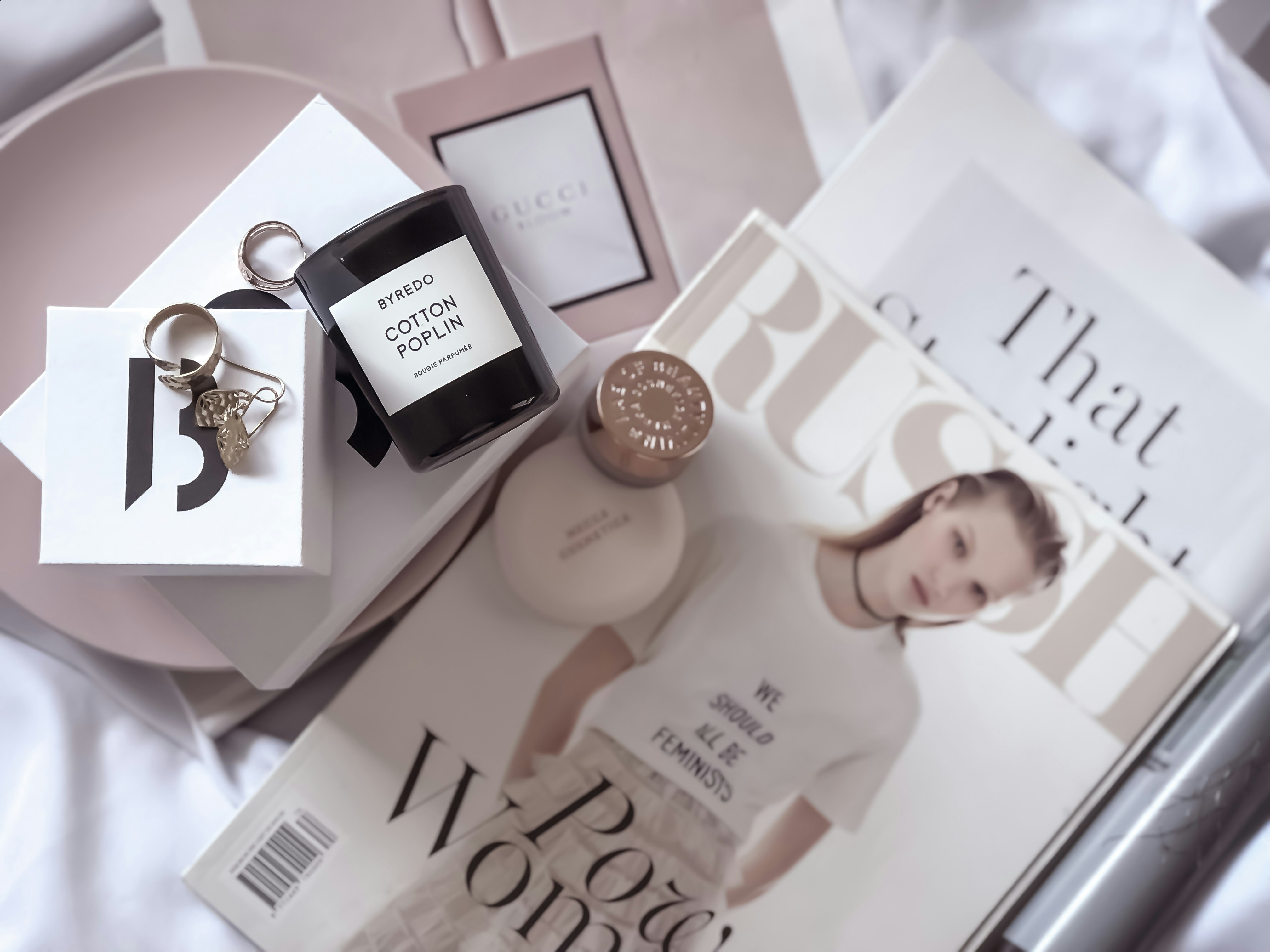 a magazine and a bottle of perfume on a bed