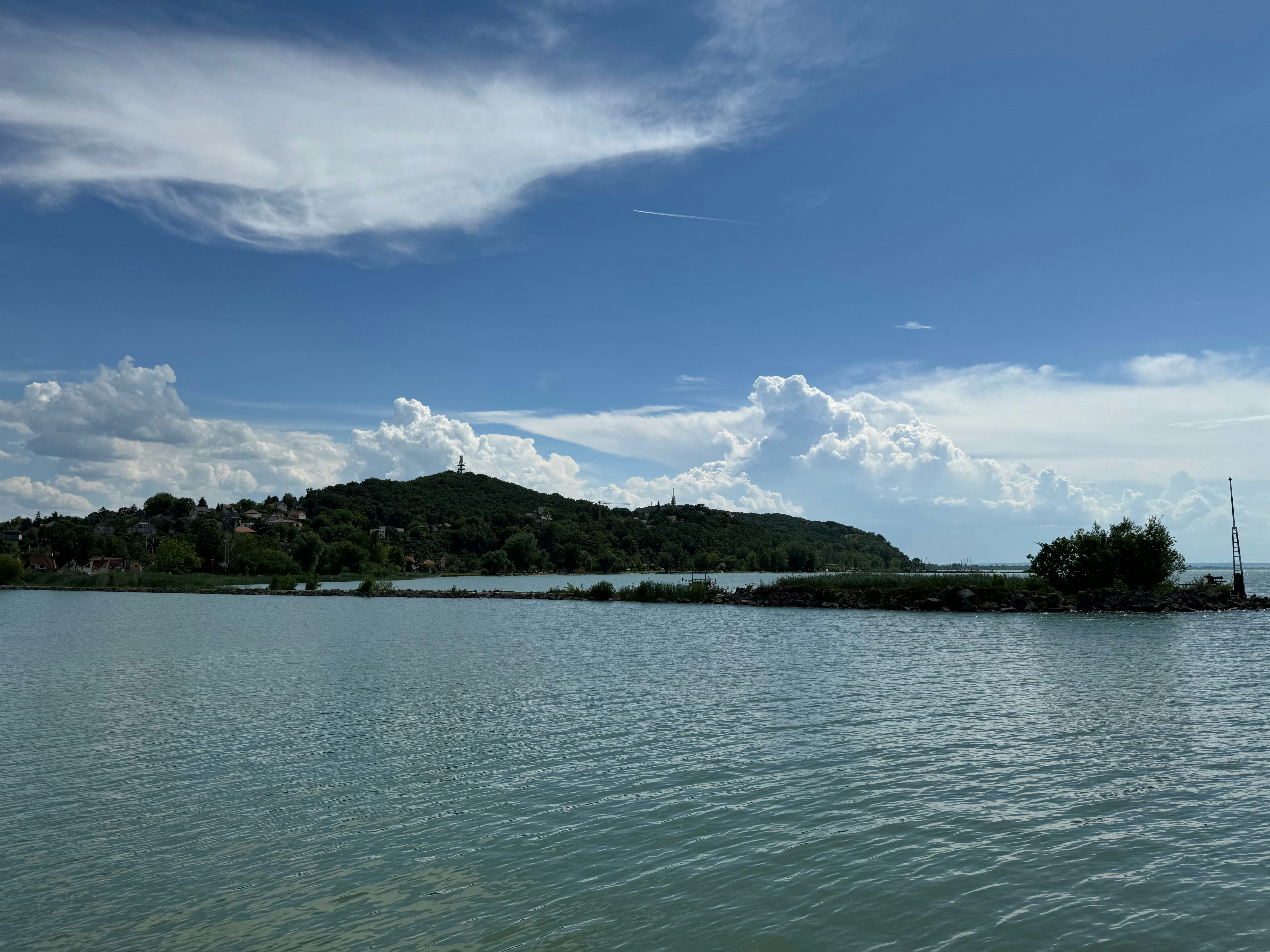 a body of water with a hill in the background