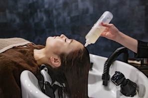 a woman getting her hair washed with a hair dryer