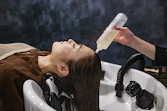 a woman getting her hair washed with a hair dryer