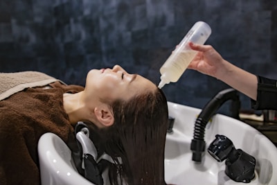 a woman getting her hair washed with a hair dryer