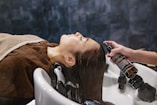 a woman getting her hair washed in a sink