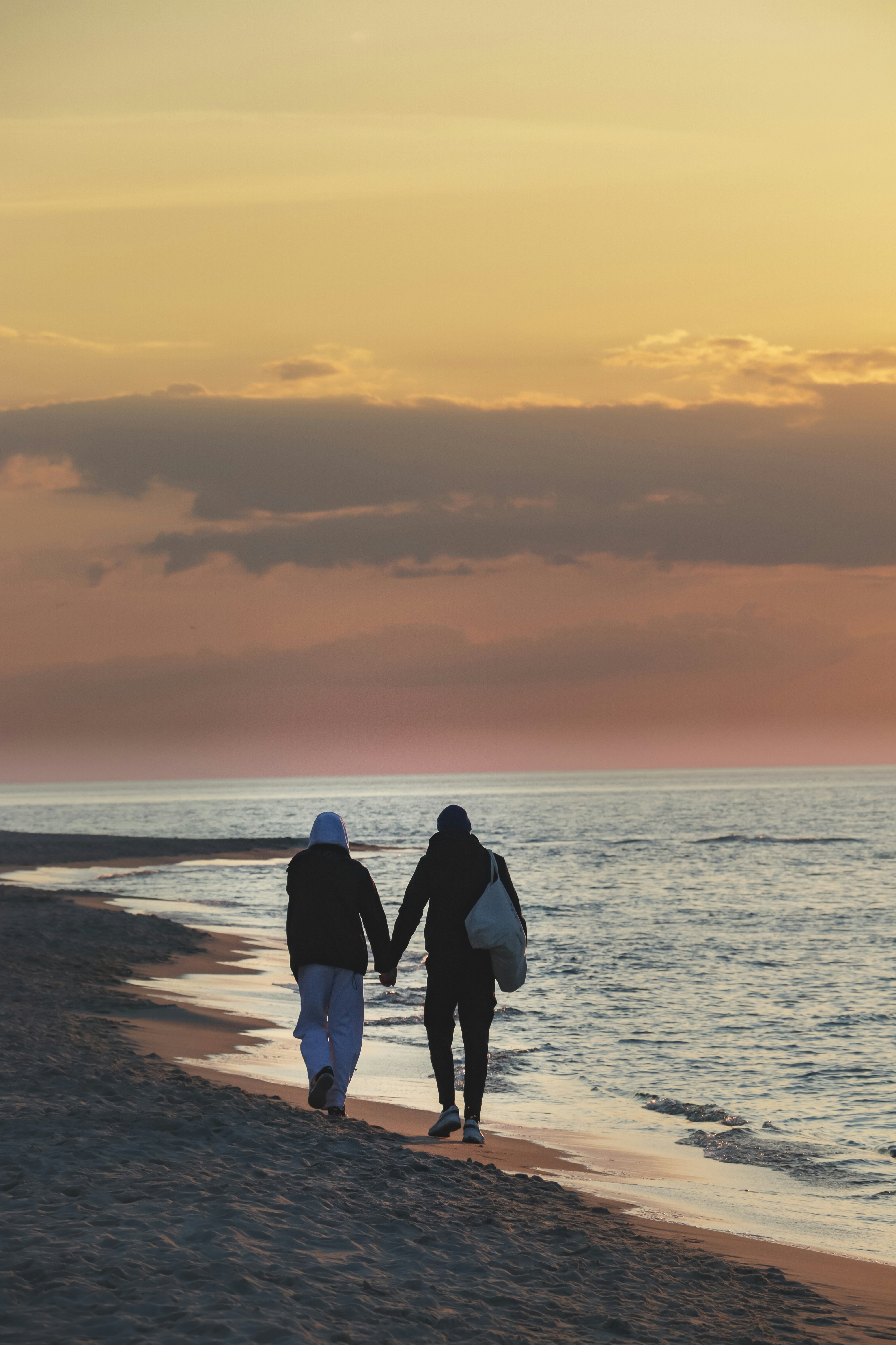 Two people walking on a beach holding hands photo – Free Sunset Image on  Unsplash, image size:3000x4500