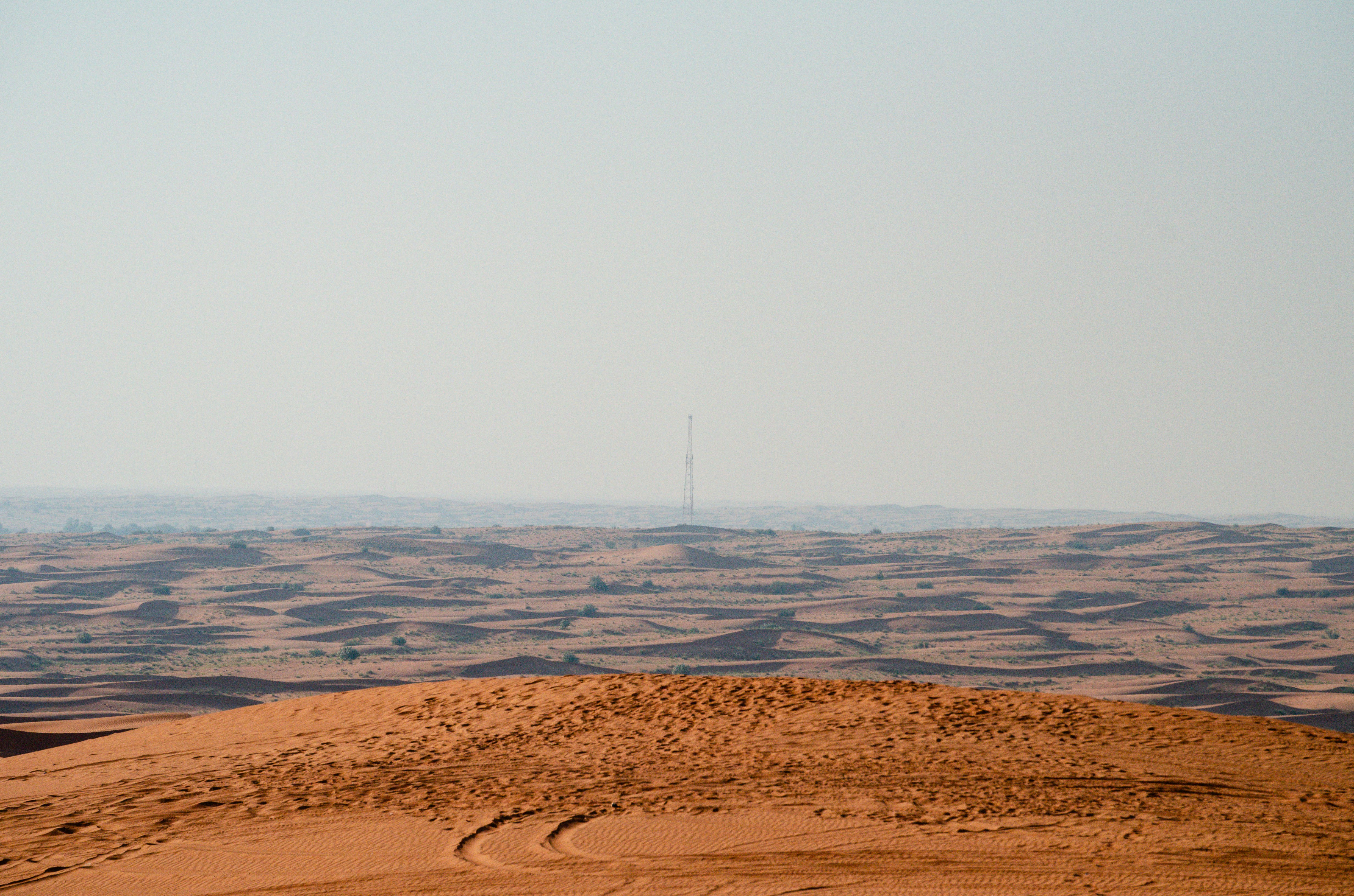 A satellite view showing a missile launch trail over a desert landscape, with a city skyline in the distant horizon, signifying conflict.