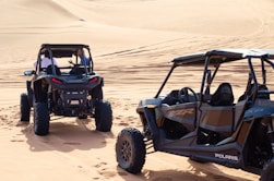 a couple of vehicles that are in the sand