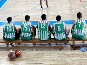 a group of men sitting on top of a wooden bench