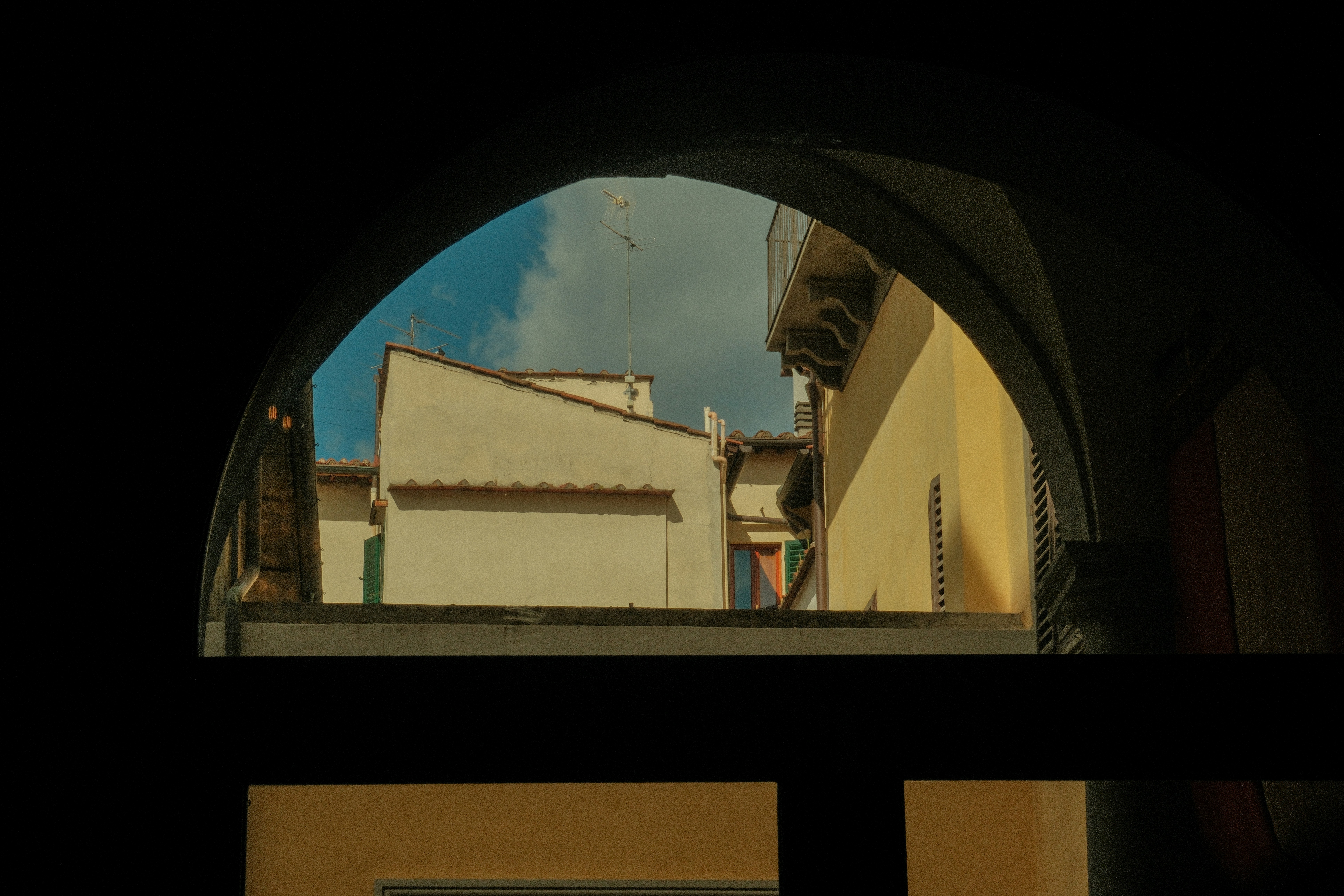 A view of a building through an arched window
