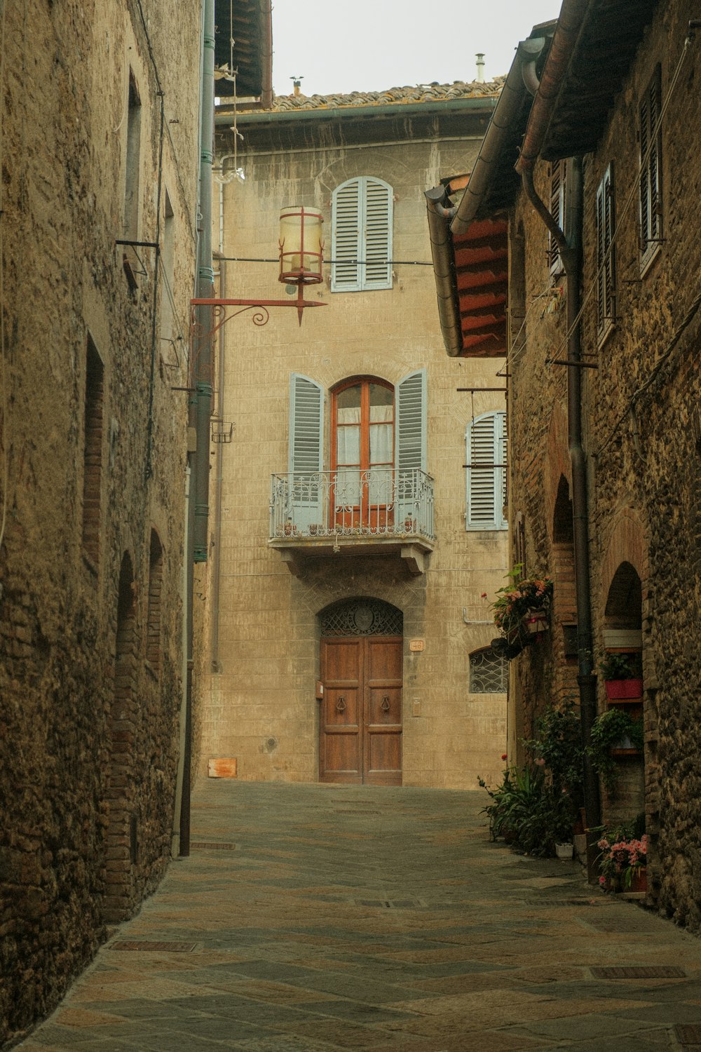 a narrow alley way with a building and a wooden door