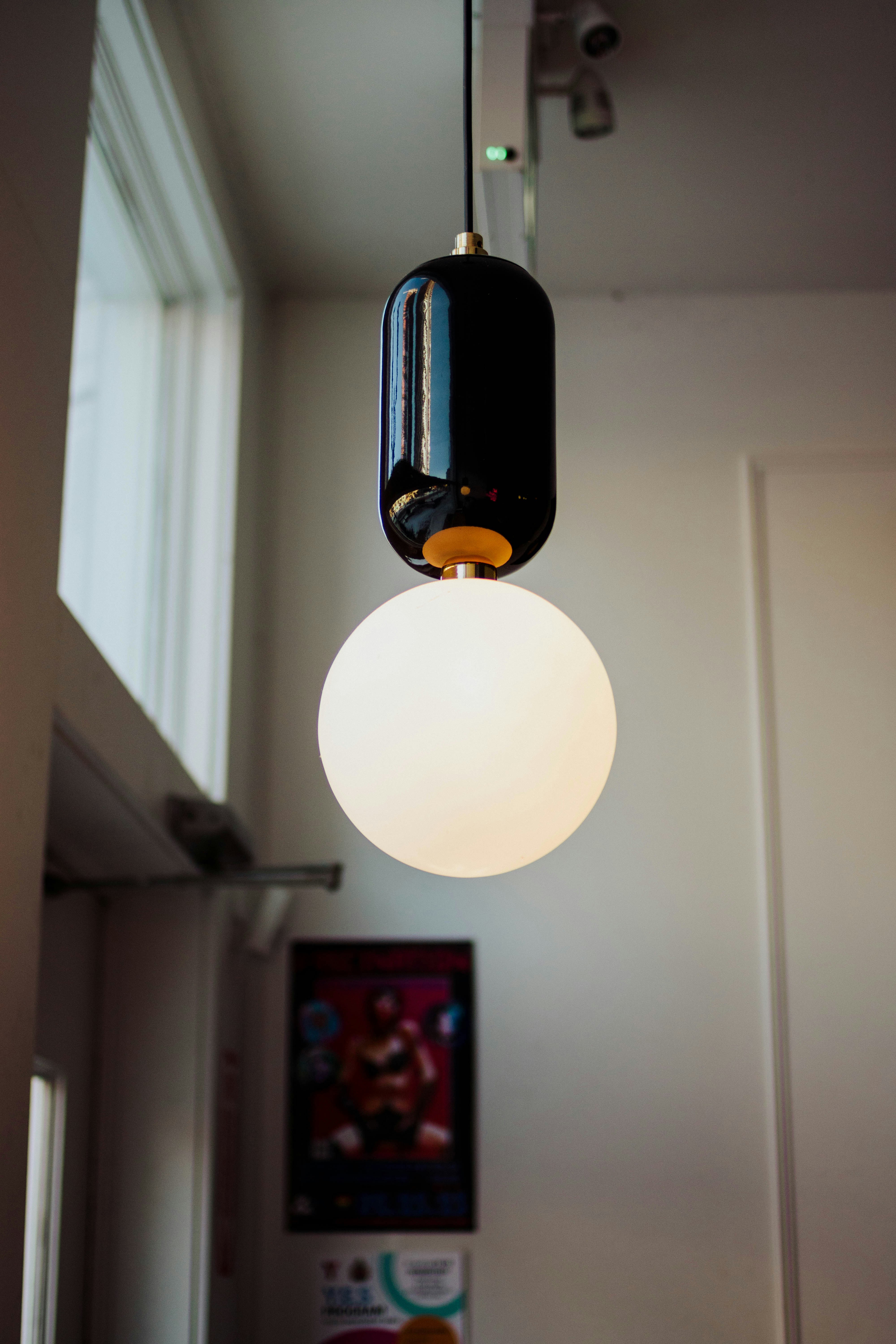 a black and white light hanging from a ceiling