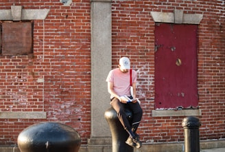 A man riding a horse in front of a brick building