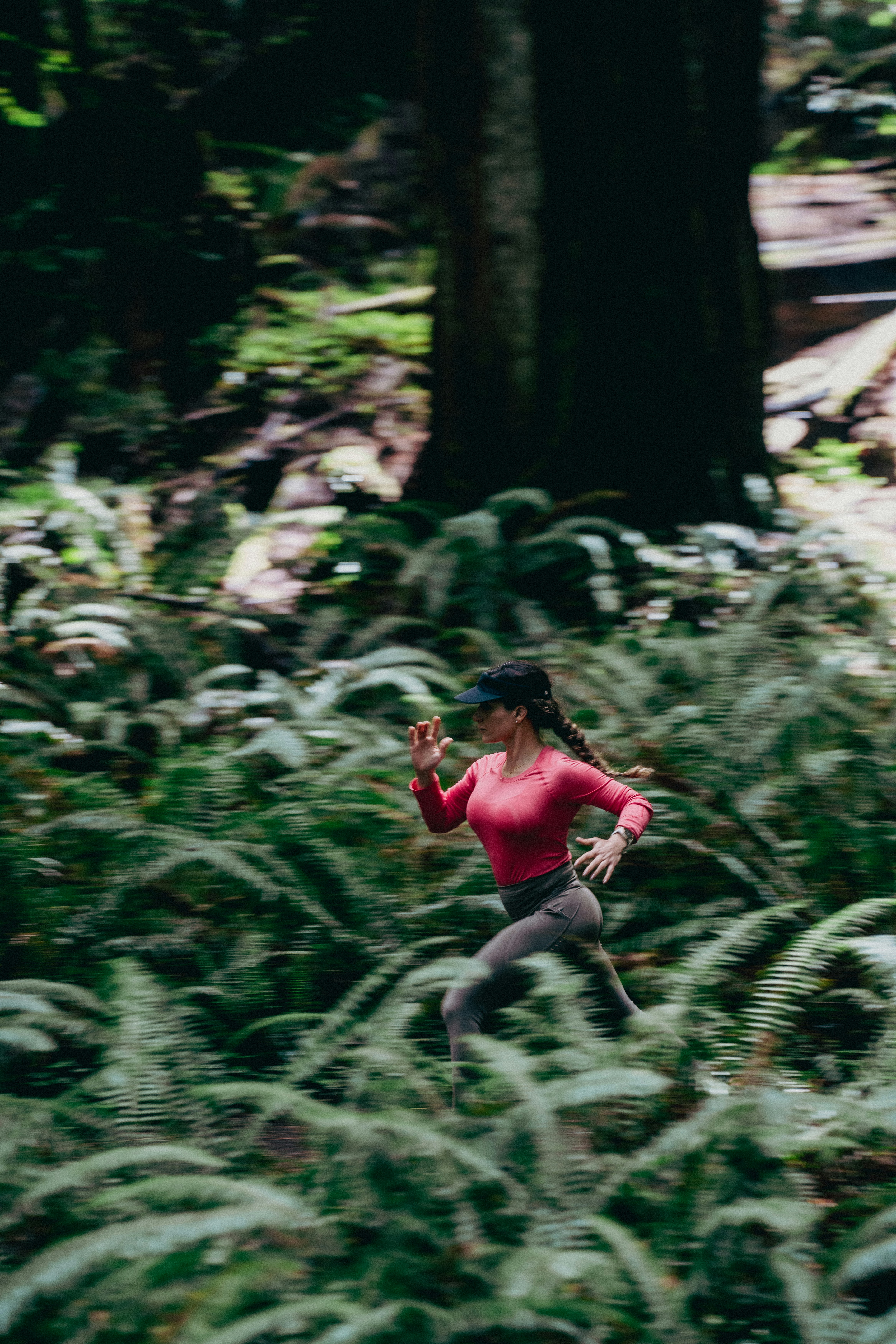 빨간 셔츠를 입은 여자가 숲을 달리고 있다