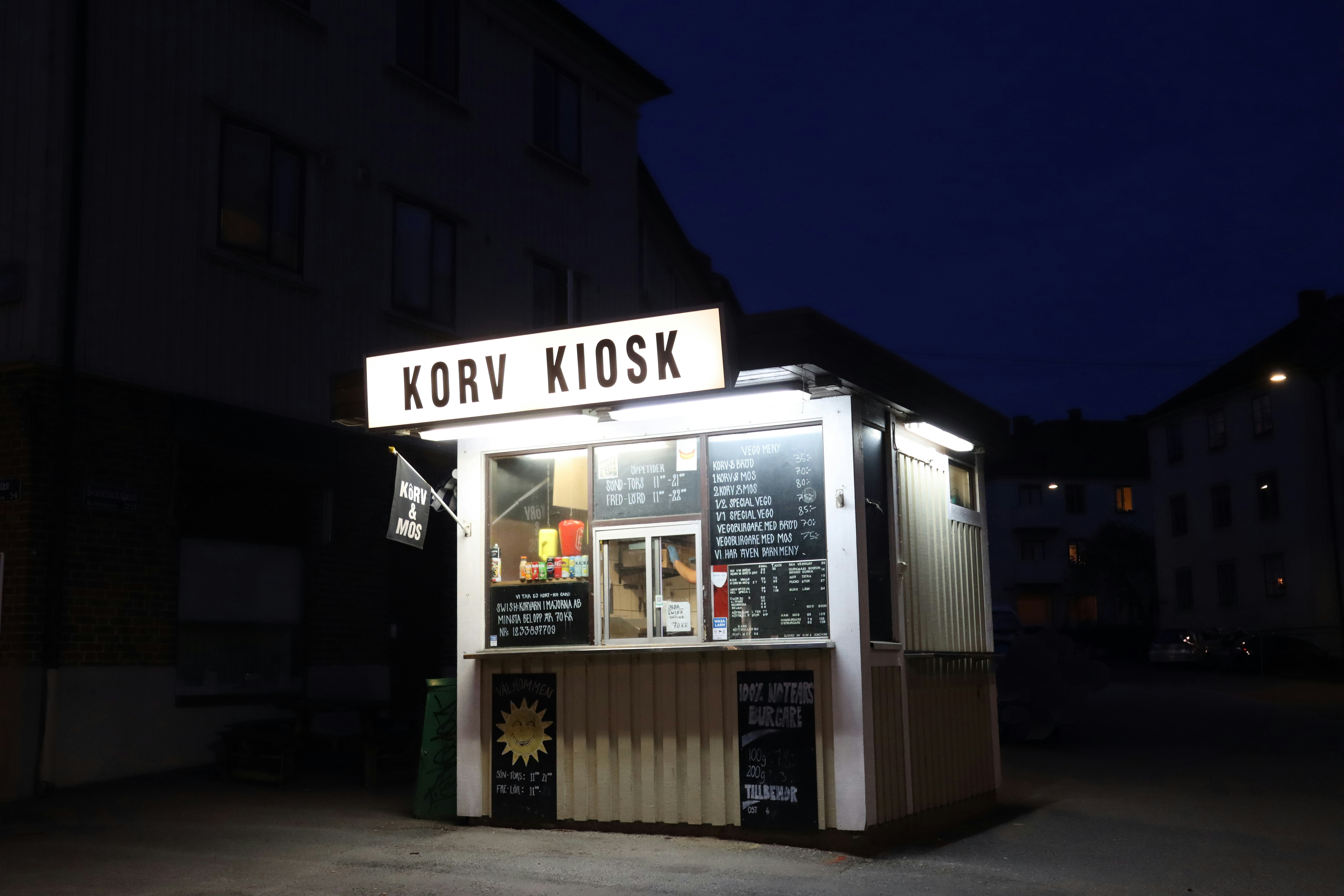 a small kiosk is lit up at night