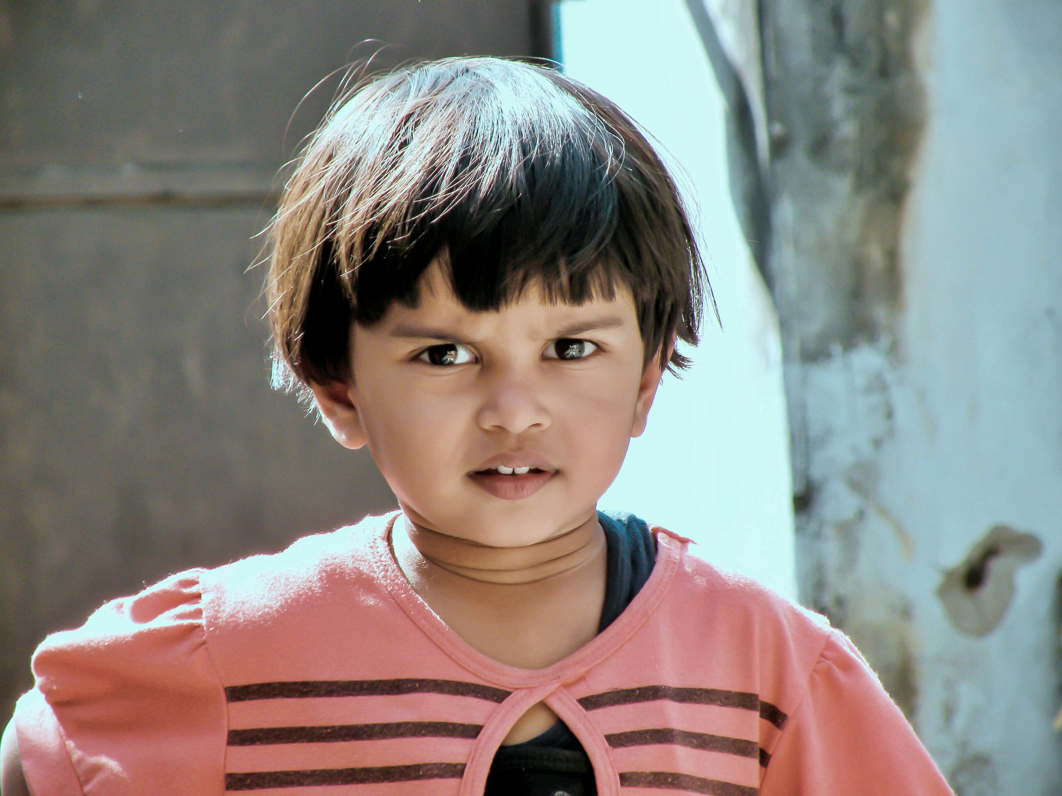 a young boy with a pink shirt and black tie