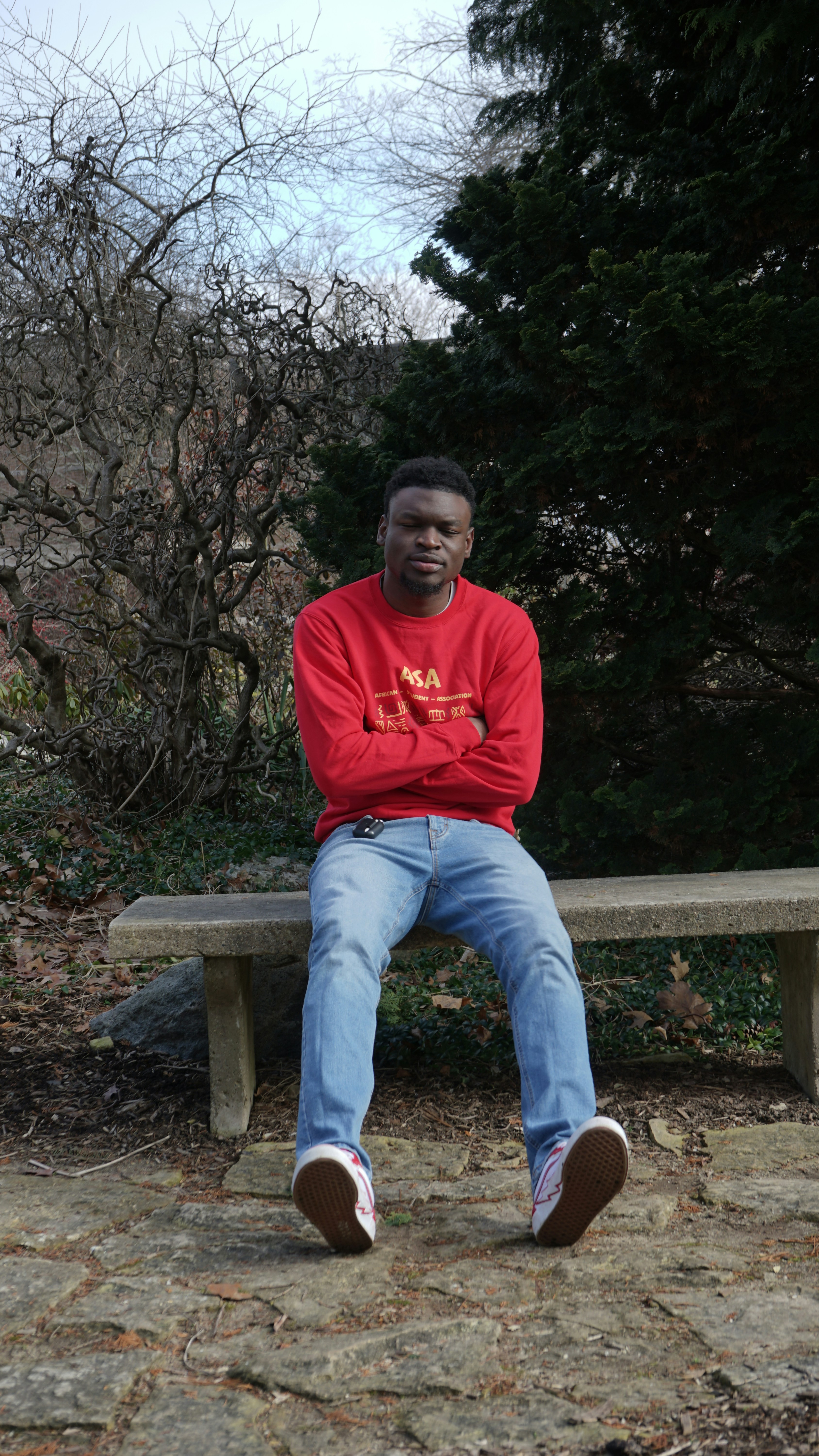 a man in a red shirt is sitting on a bench