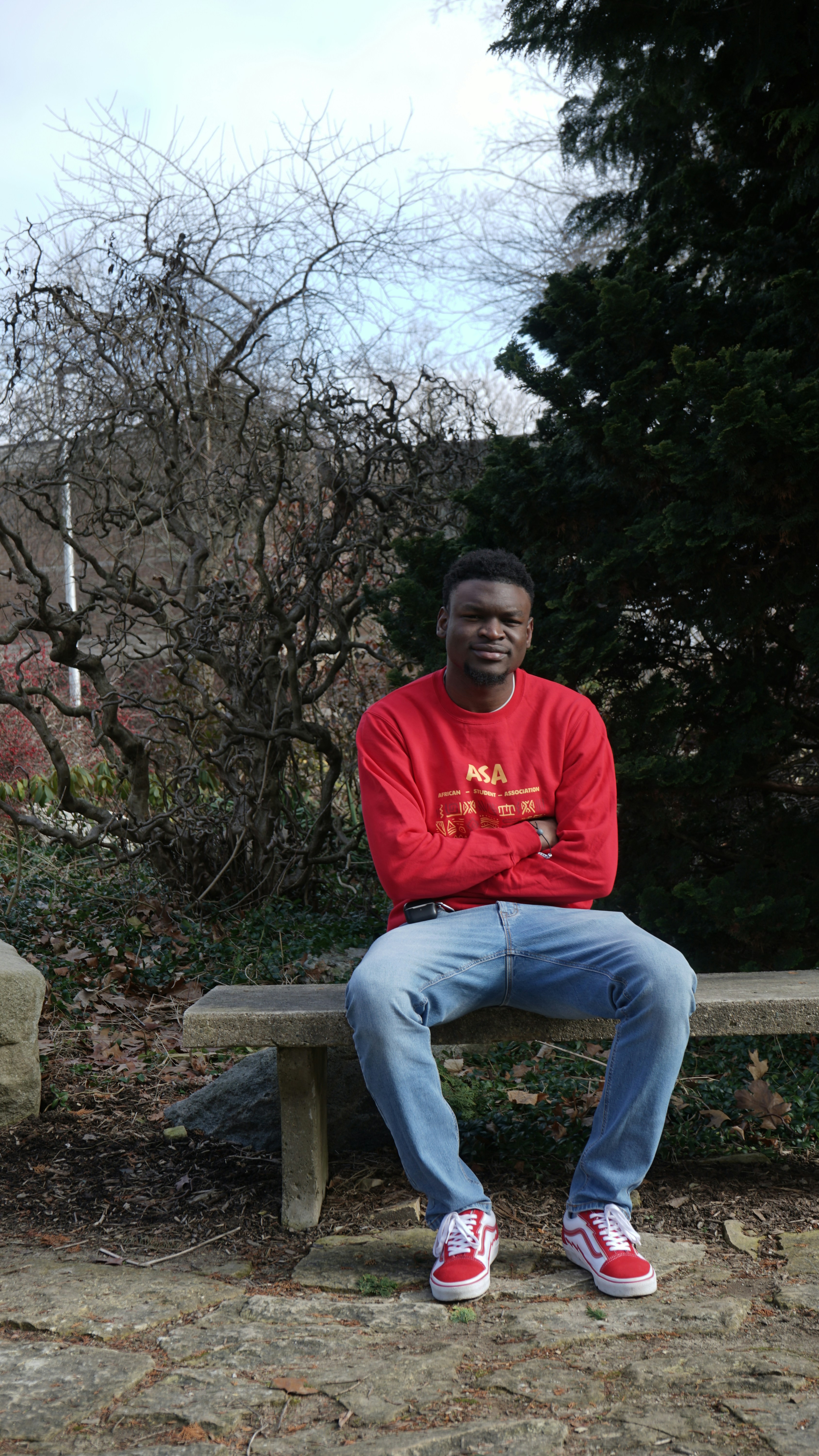 a man in a red shirt is sitting on a bench