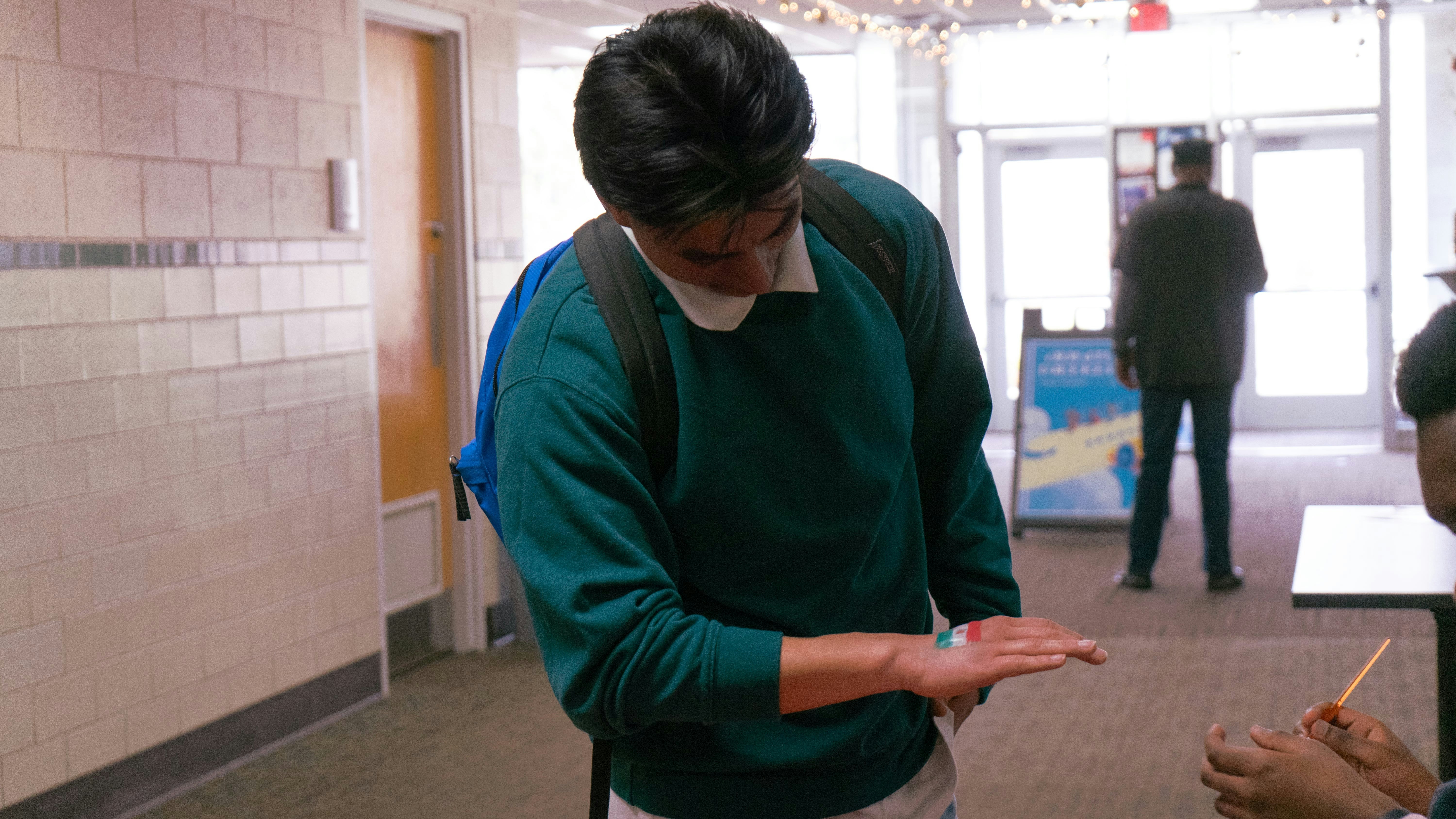 a woman in a green sweater is holding a stick