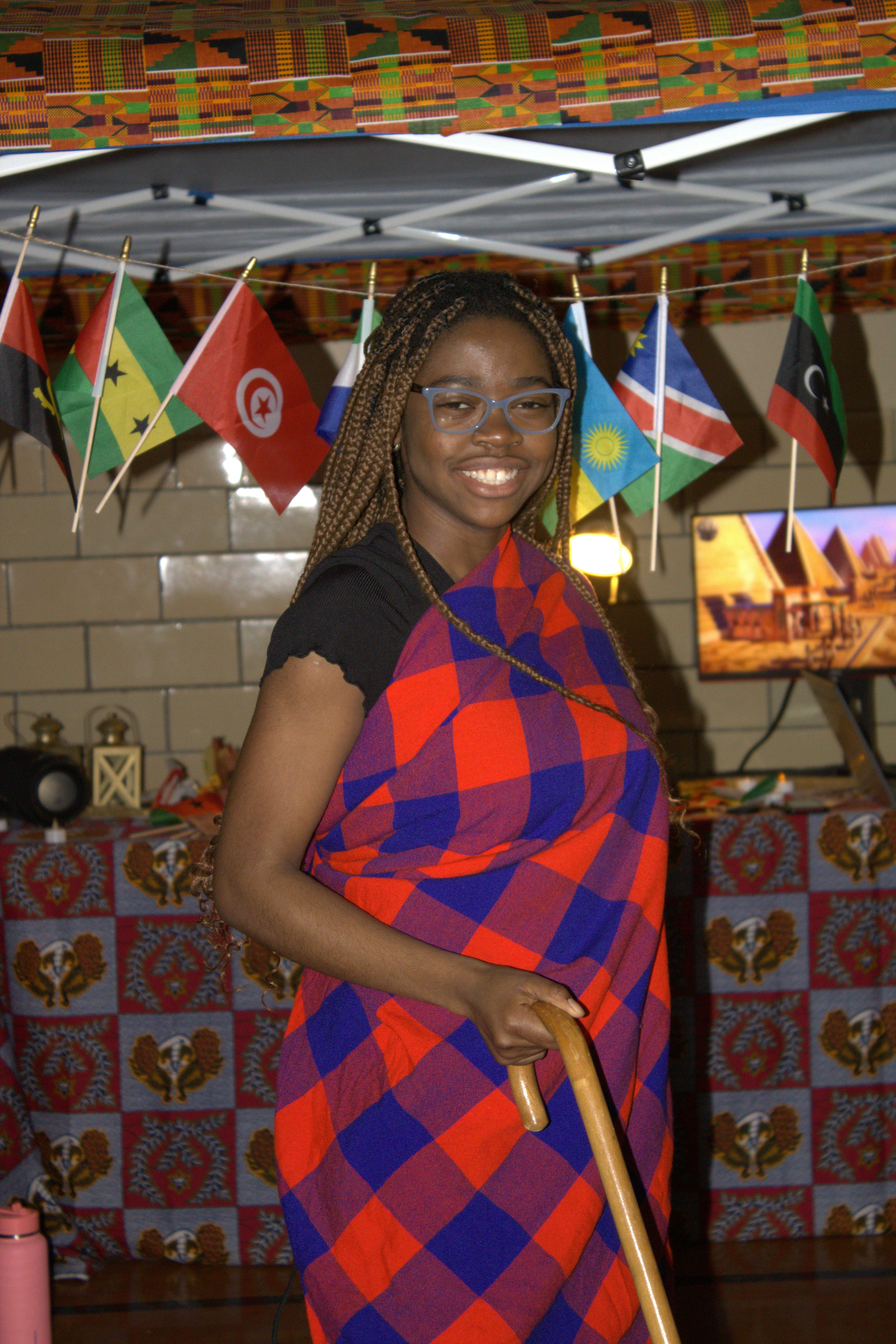 a woman standing under a canopy holding a cane