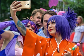 a woman with purple hair taking a picture with her cell phone