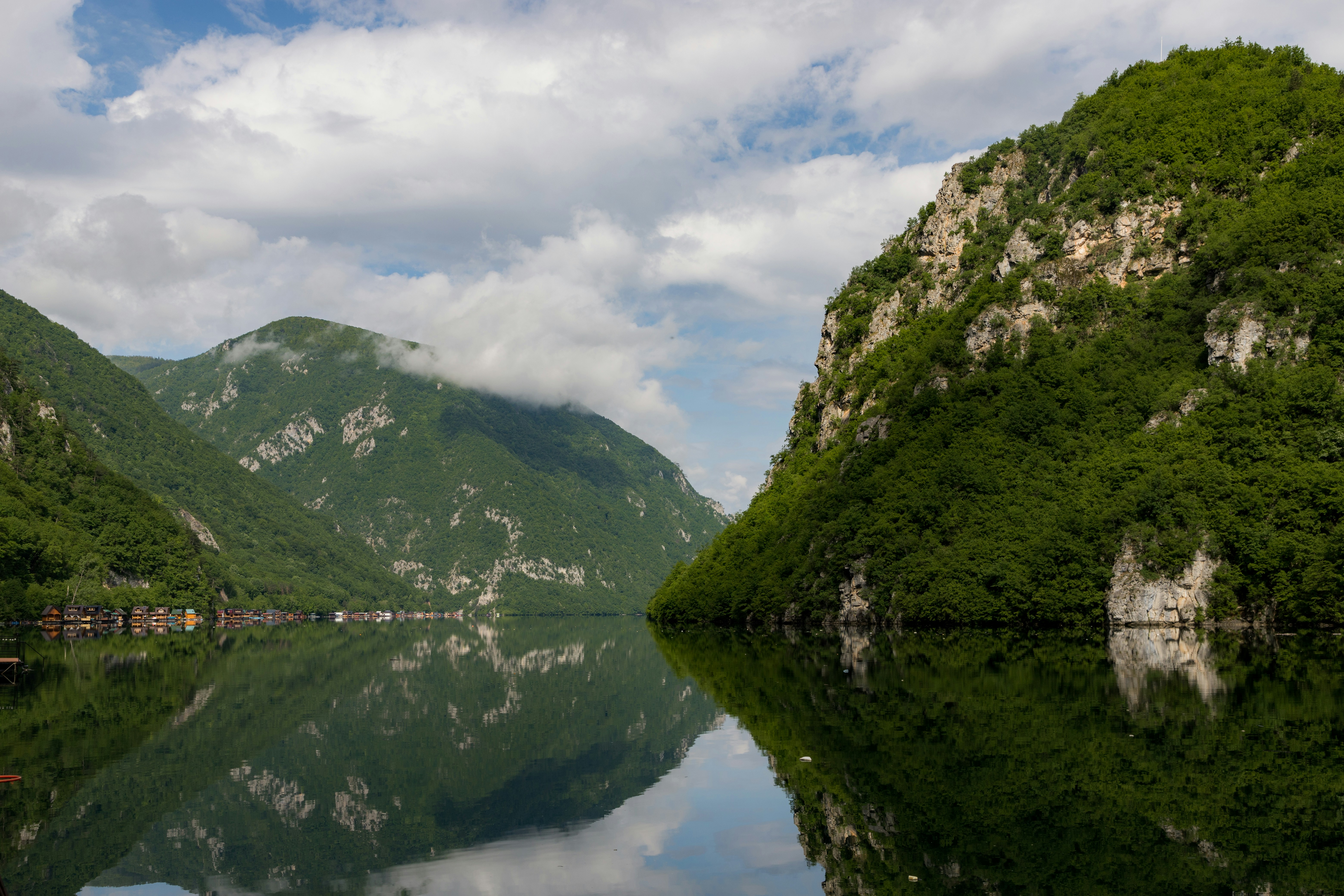 a large body of water surrounded by mountains, A panoramic view of the Perućac Lake, an artificial reservoir on the Drina River, straddling the border between Bosnia and Herzegovina and Serbia.