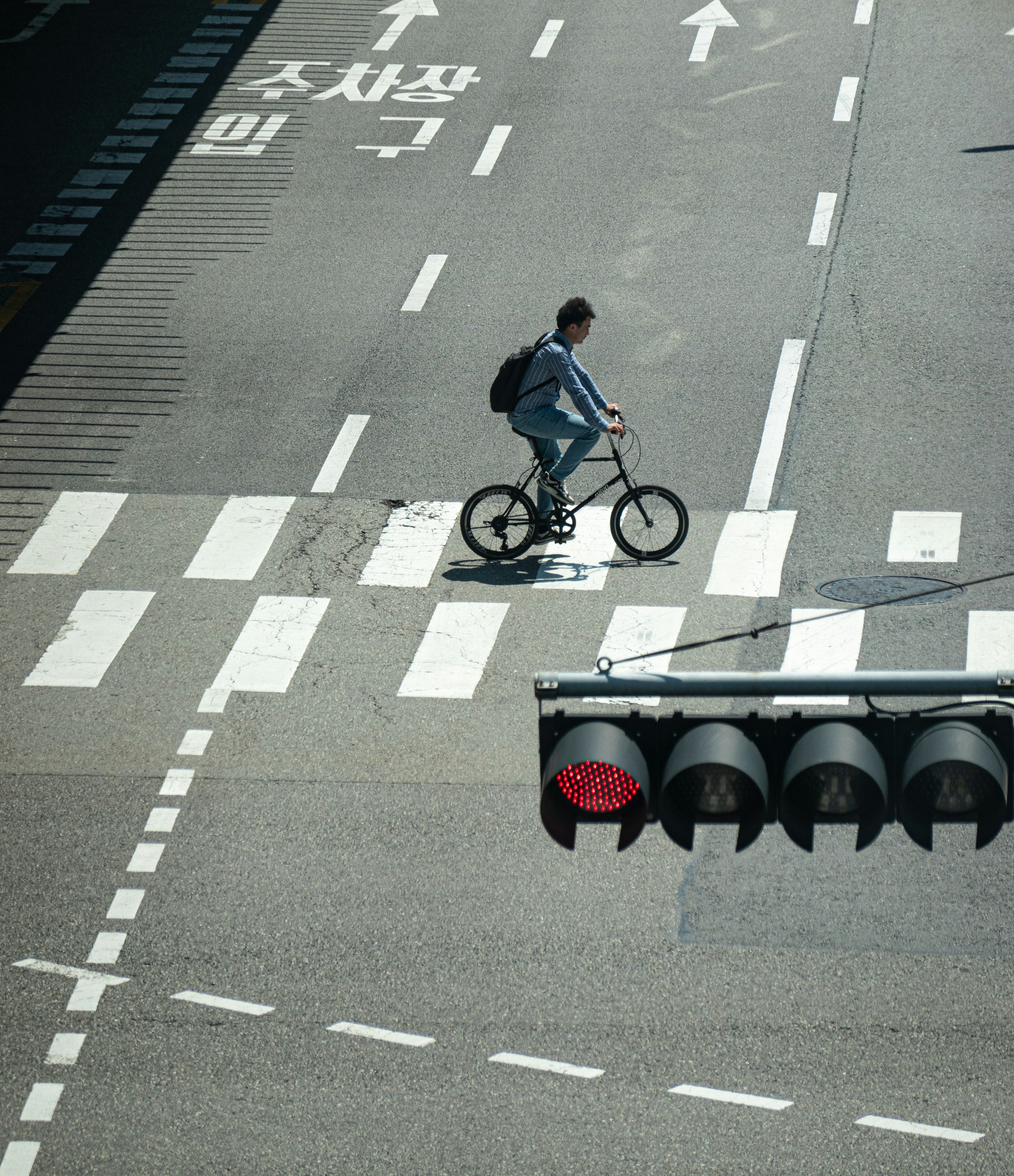 a man riding a bike down a street next to a traffic light