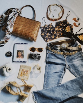a variety of clothing and accessories laid out on a bed
