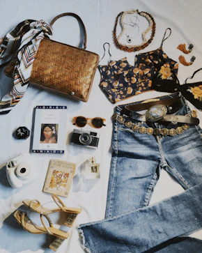 a variety of clothing and accessories laid out on a bed