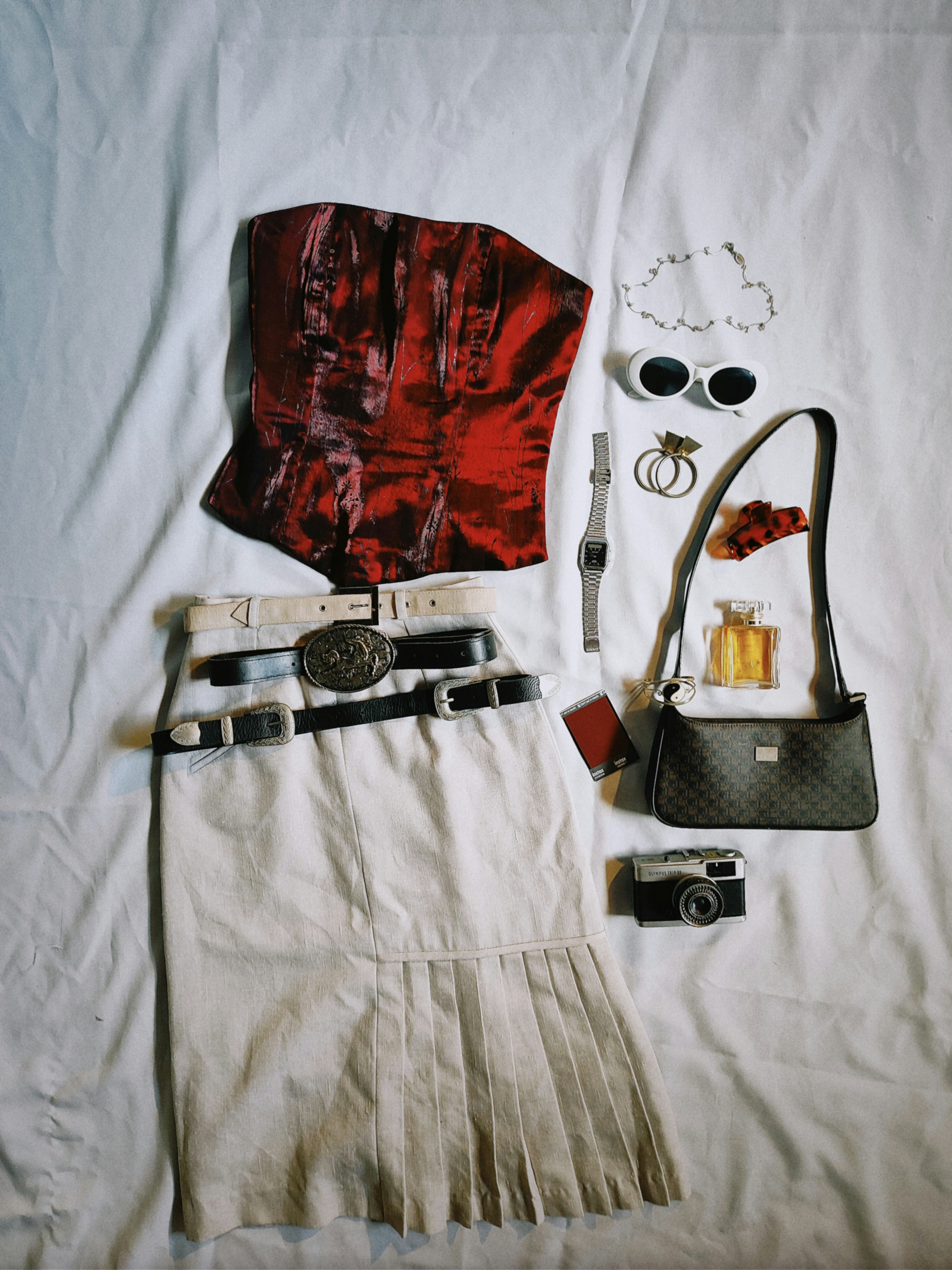 the contents of a purse laid out on a bed