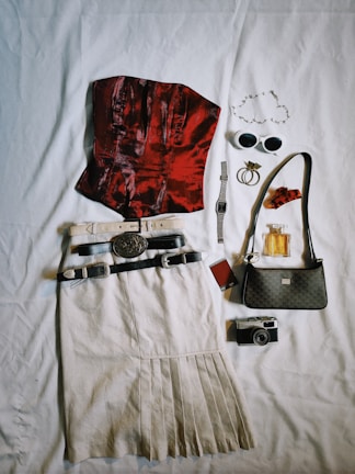 the contents of a purse laid out on a bed