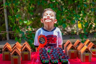 a young boy standing in front of a bunch of bird houses