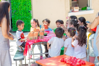 a group of children standing around a table