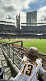 a baseball player sitting in the bleachers watching a game