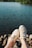 a person standing on a rocky shore next to a body of water