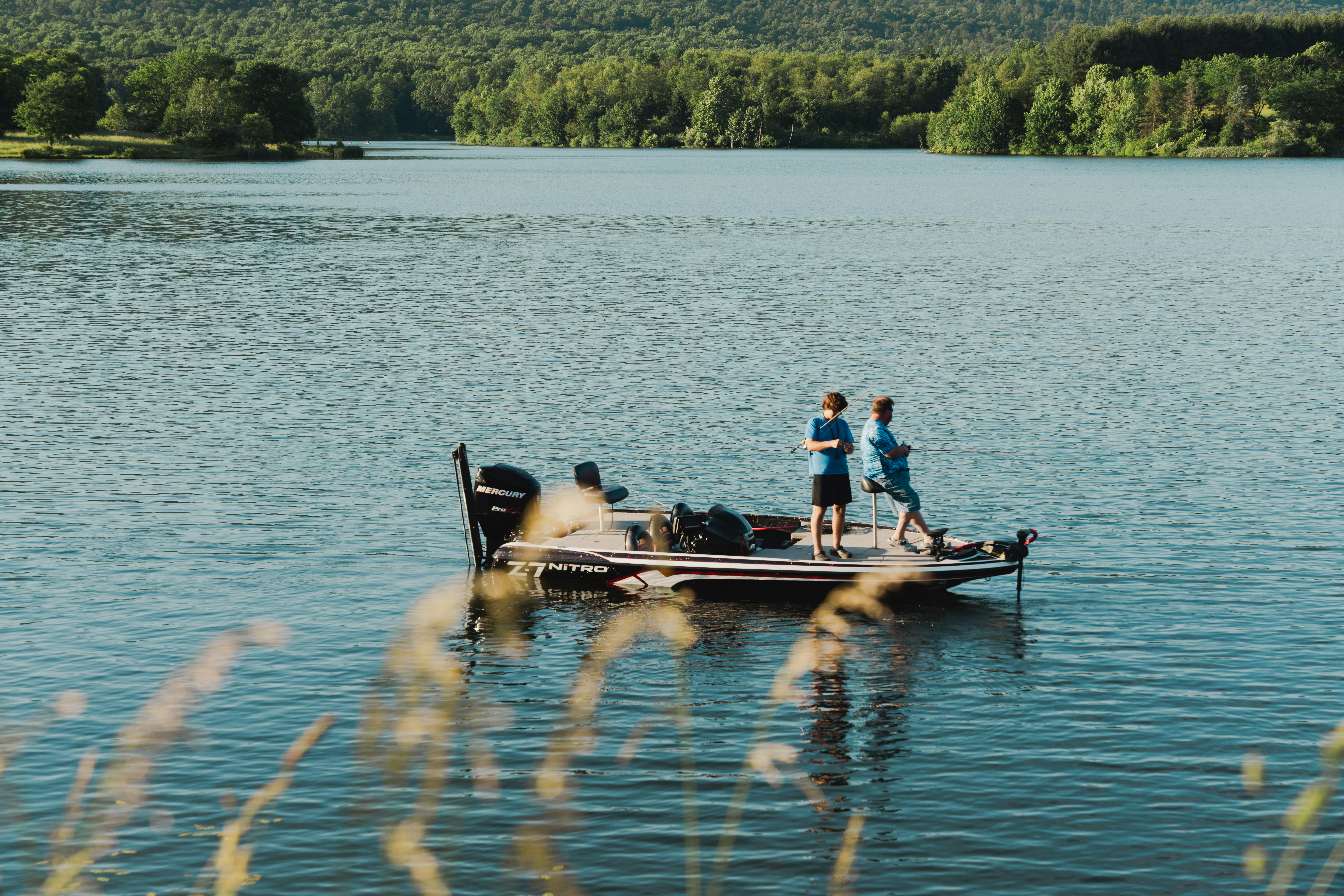 a group of people standing on top of a boat on a lake