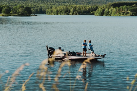 a group of people standing on top of a boat on a lake