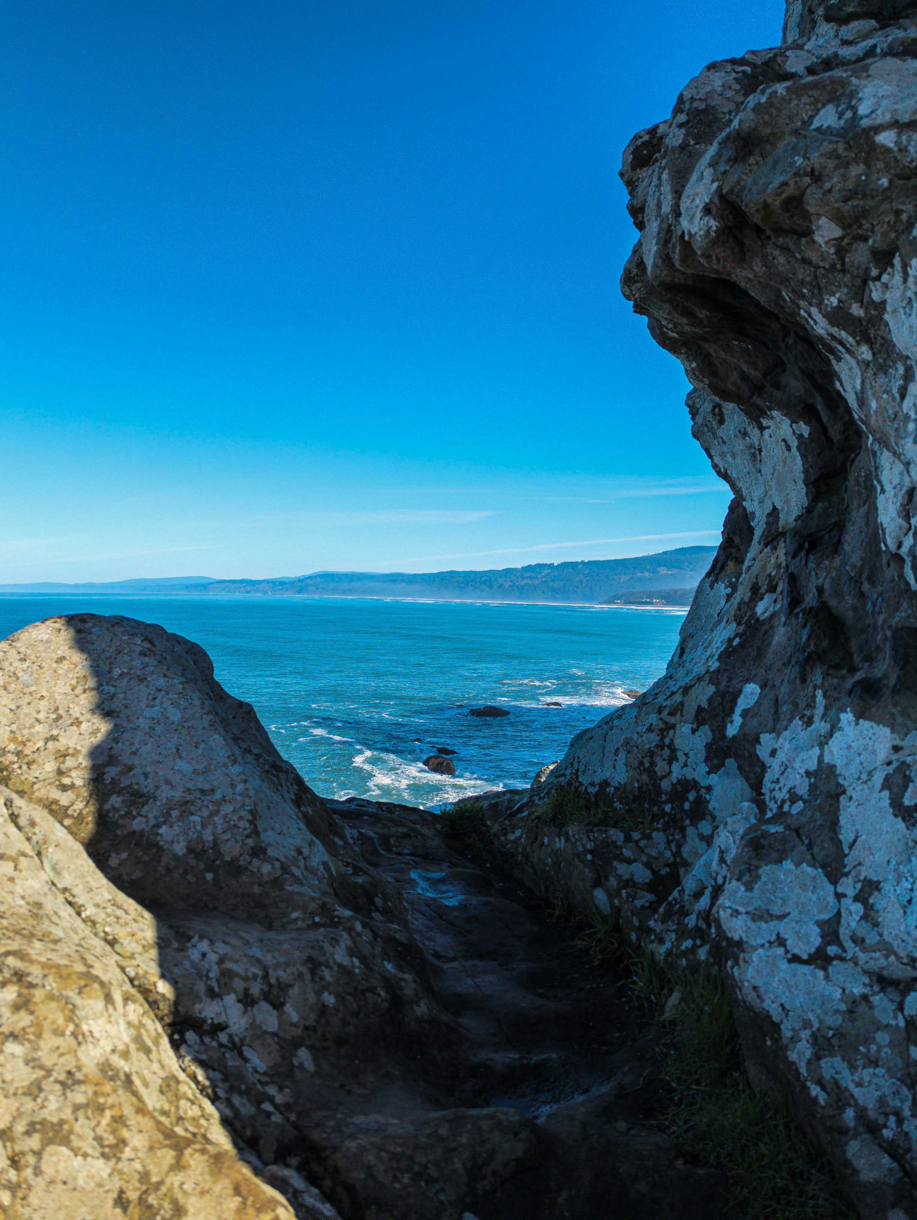 a person standing on top of a cliff next to the ocean