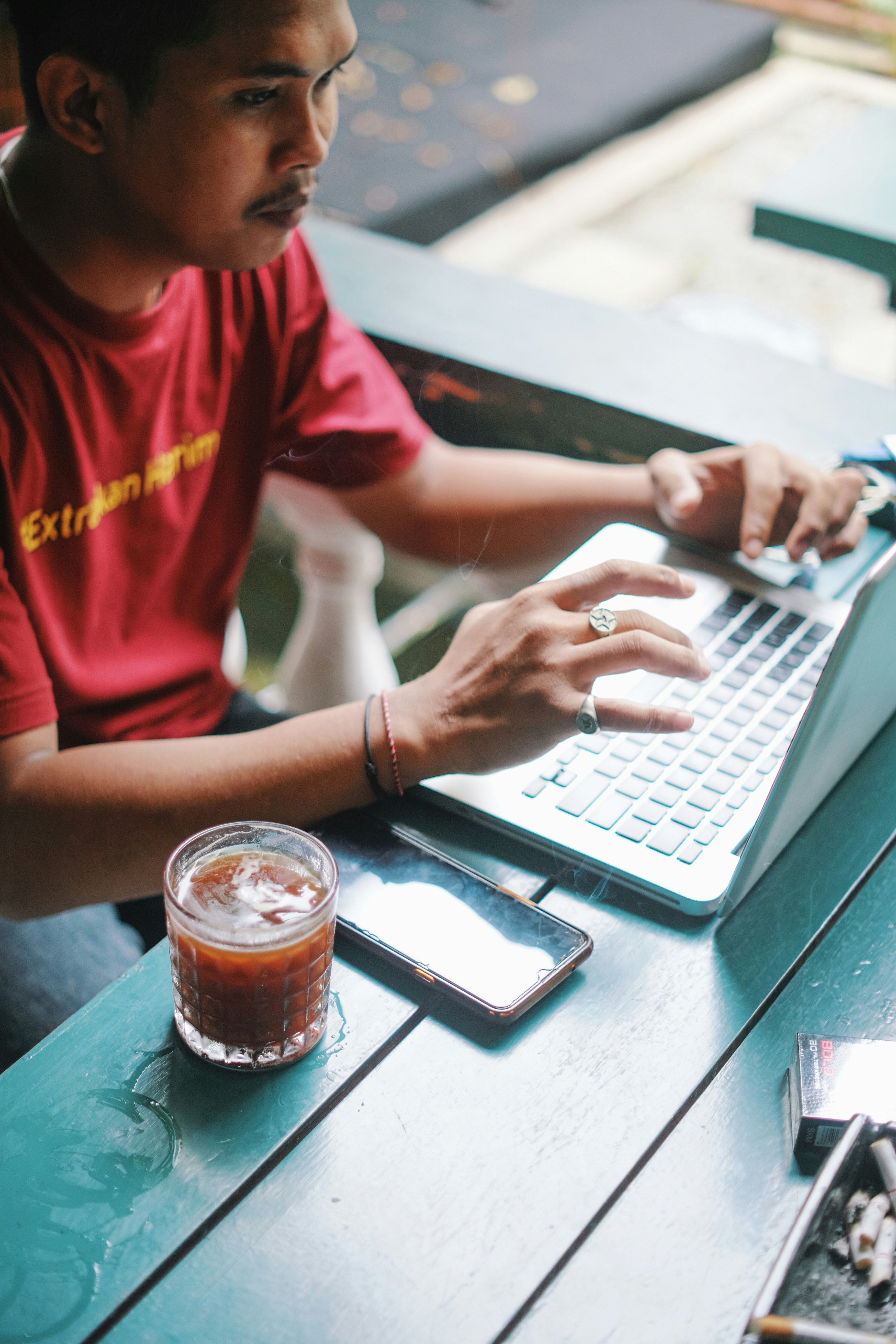seorang pria duduk di meja menggunakan komputer laptop